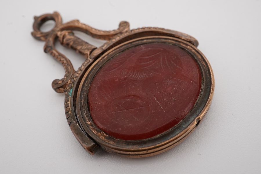 A yellow metal, seed pearl and diamond cluster seed ribbon bow brooch, width 36mm, gross weight 7.7 grams, together with a gilt metal and intaglio carnelian set spinning fob. Condition - poor to fair